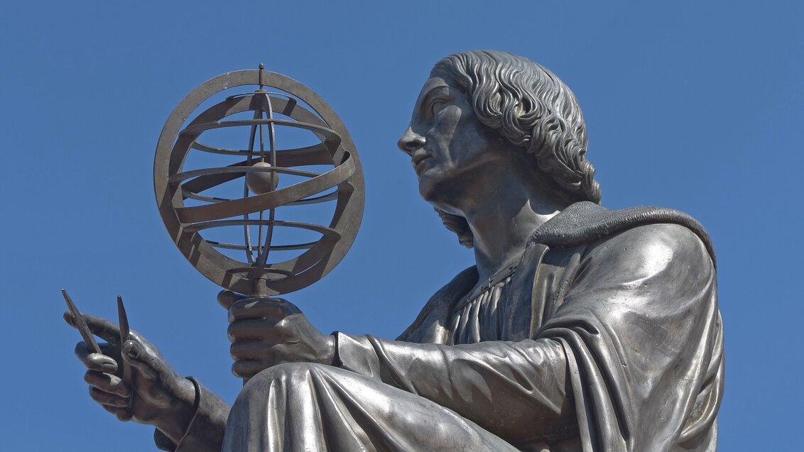 Na zdjęciu fragment pomnika Mikołaja Kopernika. Widoczna siedząca postać z przestrzenną kulą ziemską w dłoni.