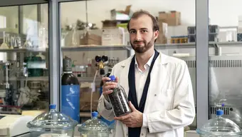 Mężczyzna prezentuje w laboratorium pojemnik z chrząszczami wykorzystywanymi w badaniach nad pozyskiwaniem chityny i chitozanu.