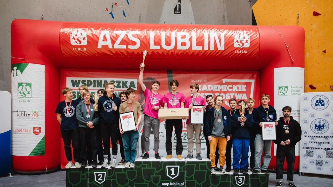 Image of students standing on a podium of a climbing championship in Lublin