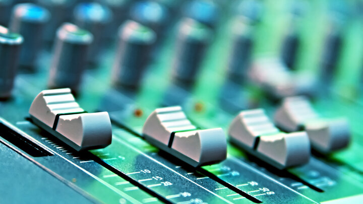 Image of a close-up on a sound mixing board