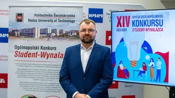Image of an elegant man in glasses standing in front of a stand of Kielce University of Technology