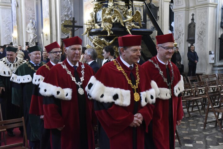 University officials in ceremonial gowns inside a church