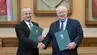 Dwóch eleganckich mężczyzn trzymających teczki stoi w sali konferencyjnej