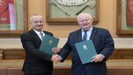 Dwóch eleganckich mężczyzn trzymających teczki stoi w sali konferencyjnej