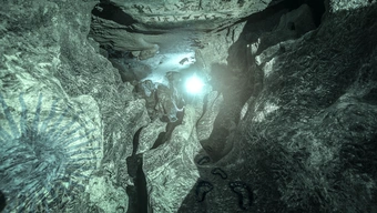 Zdjęcia wnętrza jaskini, w jej głębi widoczne światło, które może być także otworem wyjścia.