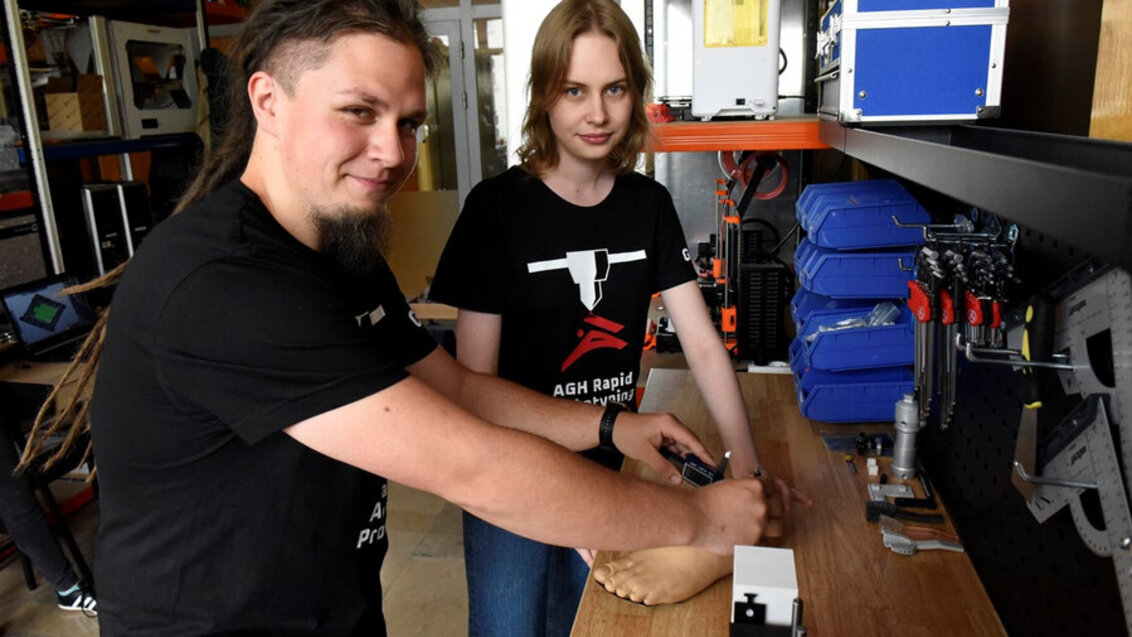 Two people working on a prosthetic foot.