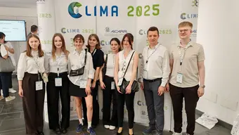 Grupowe zdjęcie zespołu Cracovian One (osiem osób) na tle kongresowego baneru.