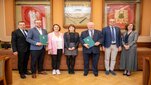 Grupa 7 stojących osób w sali konferencyjnej