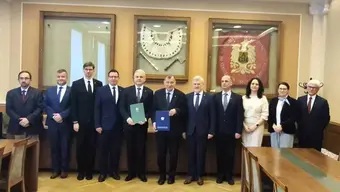 Zdjęcie grupowe kilkunastu osób, które uczestniczyły w spotkaniu. Zdjęcie wykonane w sali konferencyjnej.