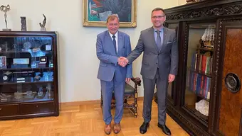 Rector’s office. In the foreground from the left: Rector Lis shakes hands with Consul General Wojnarowski. They smile and look at the camera.