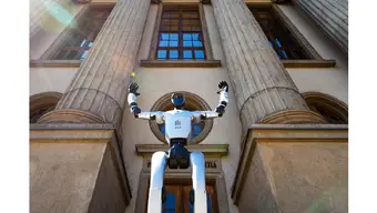 Zdjęcie fragmentu okładki "Biuletynu": robot humanoidalny Barbara na tle wejścia do budynku A0 AGH 