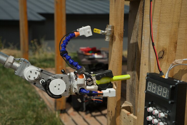 The planetary rover’s manipulator is carrying out a maintenance task on the technical system.