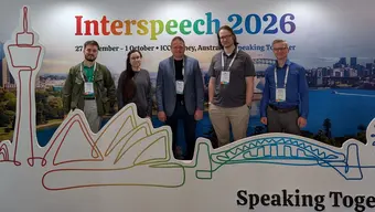 Autorzy publikacji pozują do zdjęcia na tle konferencyjnego baneru.