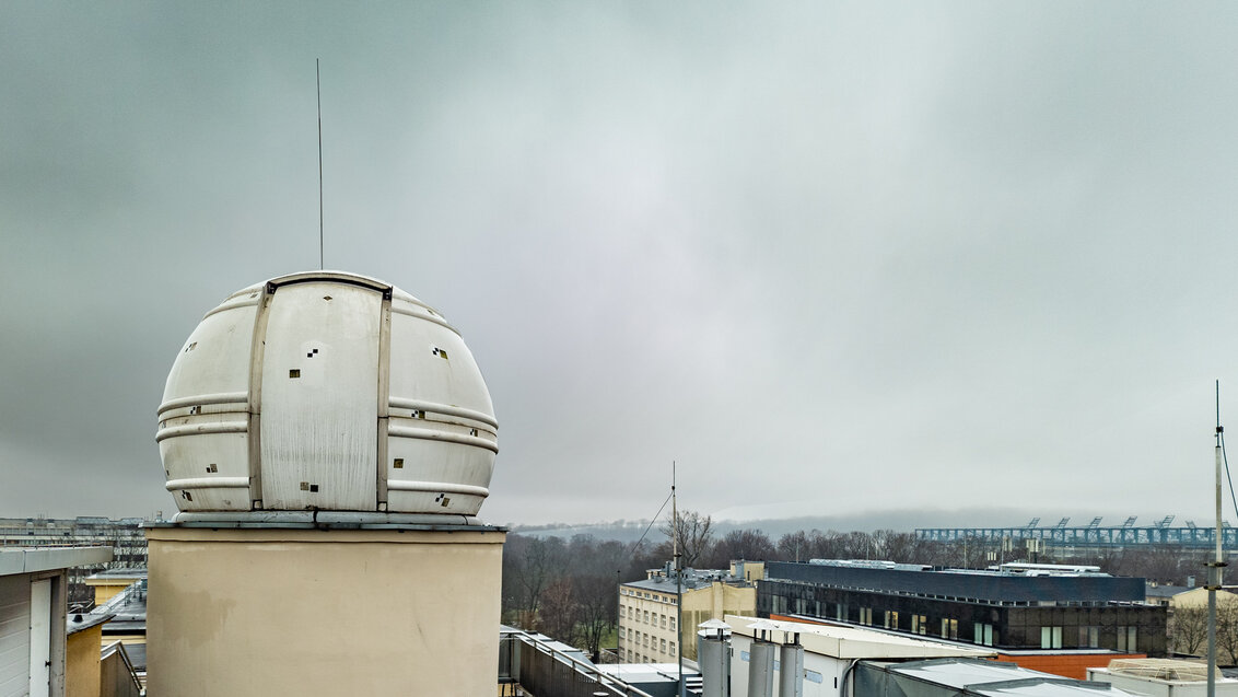 The dome of the observatory on the roof of the Faculty of Geo-Data Science, Geodesy, and Environmental Engineering. Roofs of other buildings on the AGH UST campus in the background.
