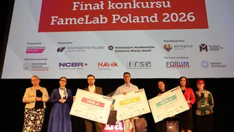 Laureaci finału konkursu FameLab Poland 2026 stoją na scenie i prezentują symboliczne czeki z nagrodami. W tle widoczny ekran z nazwą wydarzenia oraz logotypami organizatorów, partnerów i patronatów.