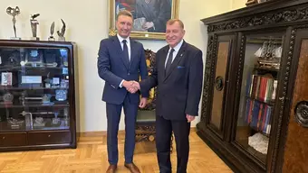 Na zdjęciu rektorzy obu uczelni stoją obok siebie, podając sobie prawe dłonie w uścisku. Zdjęcie wykonane w gabinecie Rektora AGH.