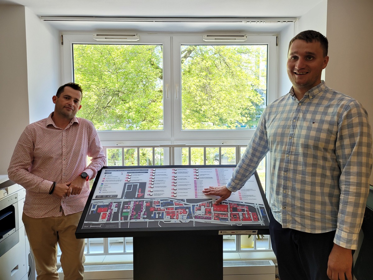 Two men standing next to a scaled-down version of the tactile map of the AGH UST Campus. They're smiling.