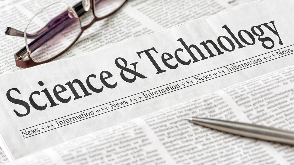 A newspaper with a headline that says "Science & Technology". A pair of glasses and a pen lying thereon.