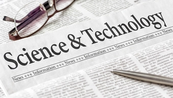 A newspaper with a headline that says "Science & Technology". A pair of glasses and a pen lying thereon.
