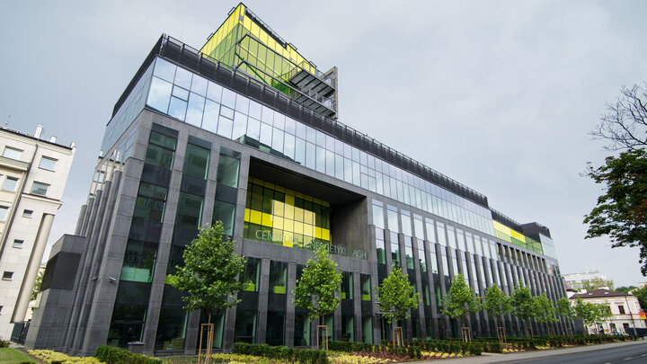 Photo of a modern building. The facade is lime-grey.