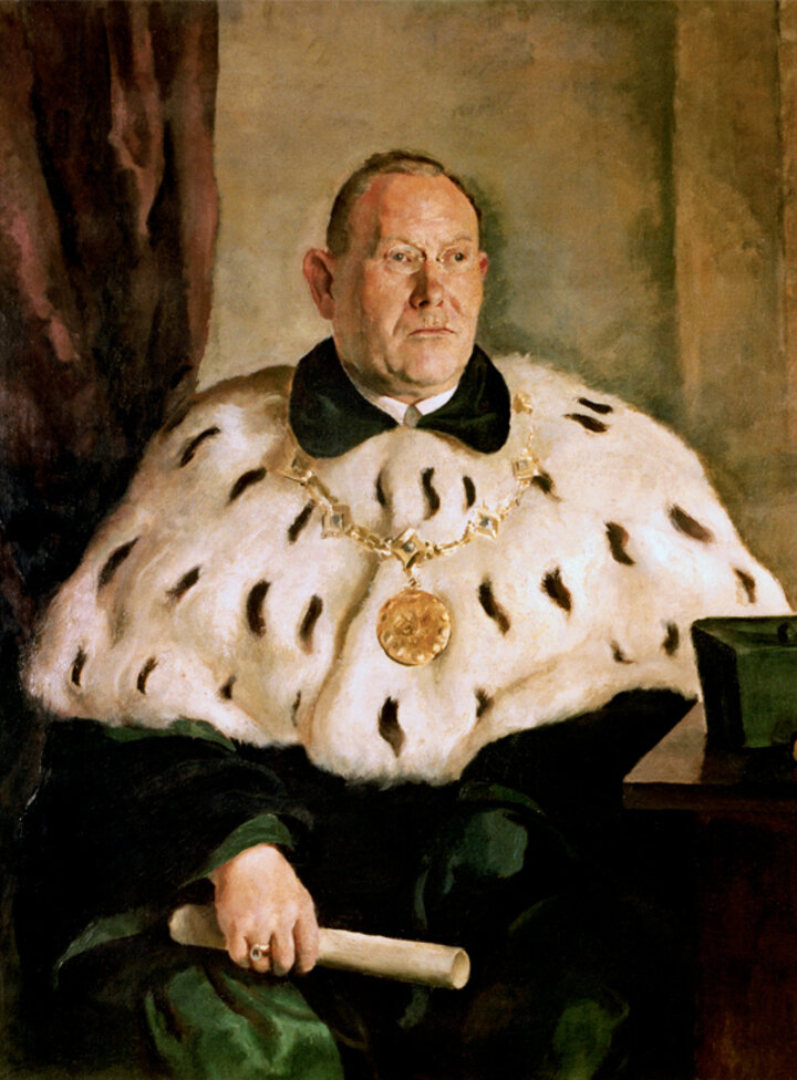 Portret Rektora Jana Krauze. Rektor ma na sobie zieloną togę, duży gronostajowy kołnierz oraz złoty ozdobny łańcuch.