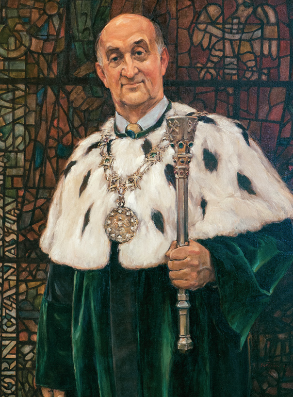 Portret Rektora Antoniego Tajdusia ubranego w zieloną togę. W ręce trzyma berło. 